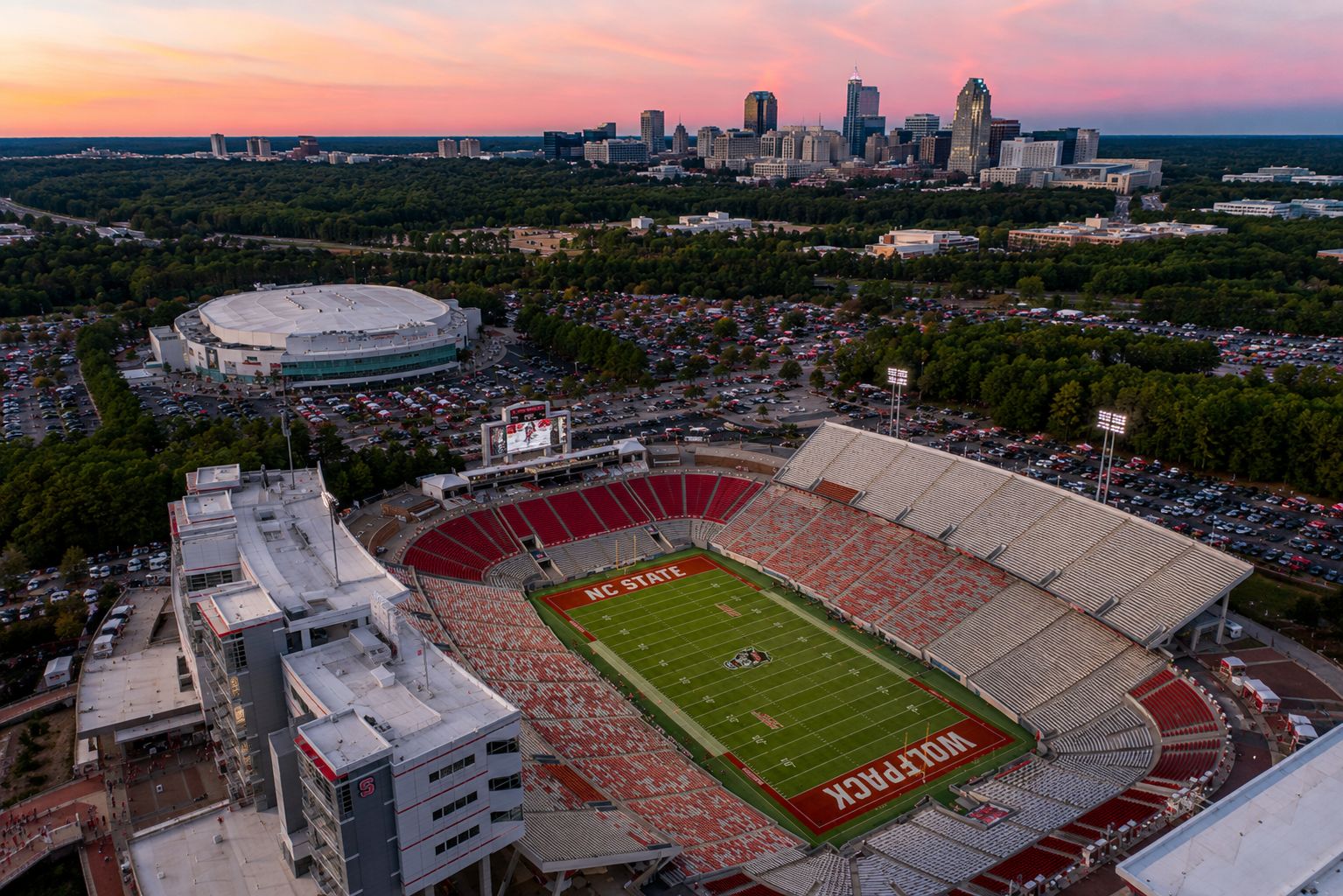 Aerial view of Carter-Finley Stadium during an NC State football game with downtown Raleigh in the distance.
